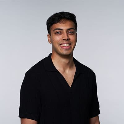 A headshot of Abhi Ghavalkar. He is wearing a black shirt and smiling at the camera.